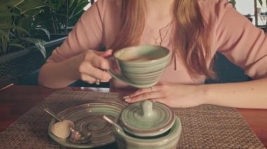 Mutlu gülüşlü, kafede kahve içen genç bayana yaklaş.