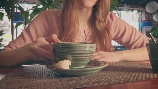 Гарна жінка з закритими очима п'є каву в кафе — стокове відео