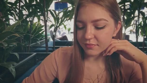Молода жінка в кафе п'є каву крупним планом постріл — стокове відео
