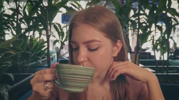 Trevlig dam på kafé dricker kaffe närbild tilt skott — Stockvideo