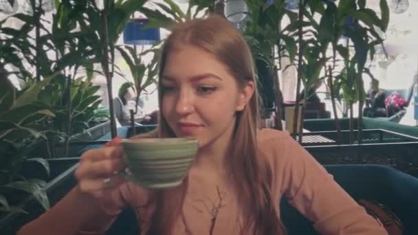 카페에서 커피를 마시는 젊은 여성의 모습 — 비디오