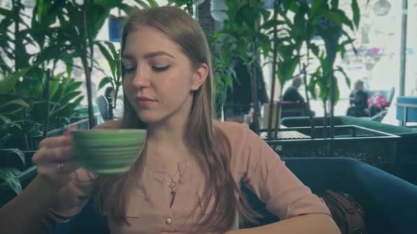 Panning närbild av flickan dricker kaffe från strippad kopp — Stockvideo