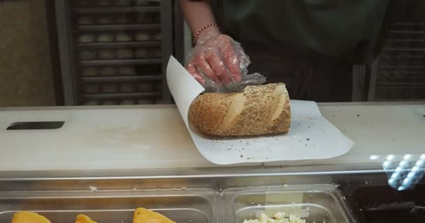 투명 장갑을 끼고 지방 패스트푸드에 치즈를 넣은 여성 — 비디오