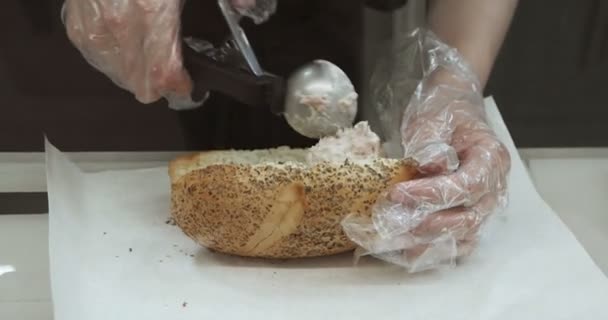 Donna in guanti trasparenti preparare panino con insalata di tonno nei fast food locali — Video Stock