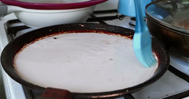 Préparation poêle peu profonde pour les crêpes friture dans le beurre avec brosse en silicone — Video