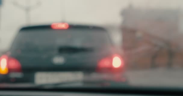 Car standing in traffic jam with windshield wipers working blurry shoot — Vídeo de stock