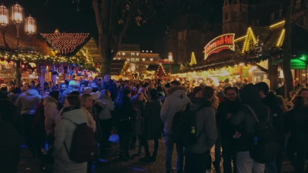 Германия, 23 декабря 2019 года: рождественская ярмарка. Множество людей стоят вокруг замедленной съемки — стоковое видео