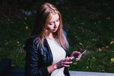 Kampüs parkındaki tablet bilgisayarıyla parkta e-öğrenim yapan bir kız öğrenci. Vintage görünümlü mat biçimi.