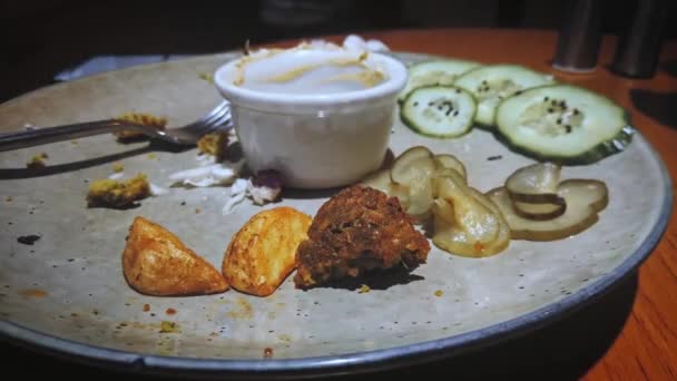 Time-lapse comer falafel fora com salada e molho. Vista lateral do prato - parar de movimento comer bolas de grão de bico com pita — Vídeo de Stock