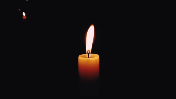 Το κερί καίγεται. Κεριά που καίγονται στο σκοτεινό δωμάτιο με ένα άλλο στο μακρινό — Αρχείο Βίντεο