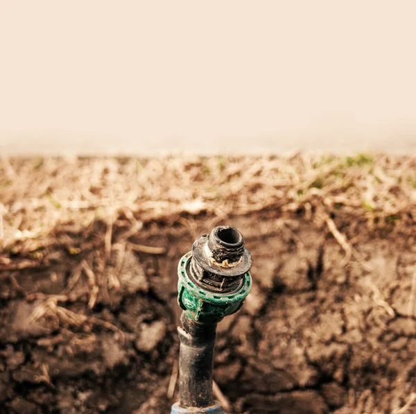 散水システムは新しい春の季節のための強姦の準備ができて地面に穴のプラスチックパイプを破った — ストック写真