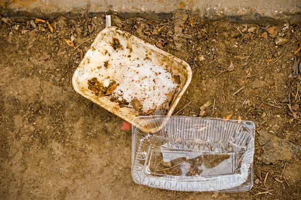 Nedskräpningskoncept Två Plastförpackningar Öppen Jord Biologiskt Nedbrytbara Material — Stockfoto