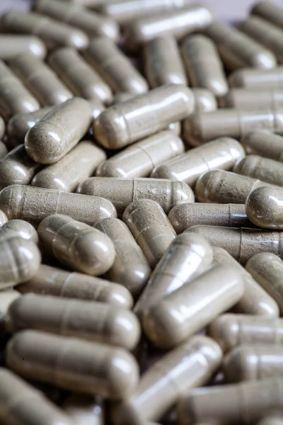 Organic plant medicine pills vertical macro image. Many pills macro backlit.