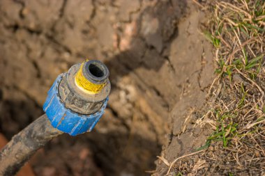 Çimenlikteki hendeğin içindeki eski plastik sulama borusu. Arka bahçe işleri.