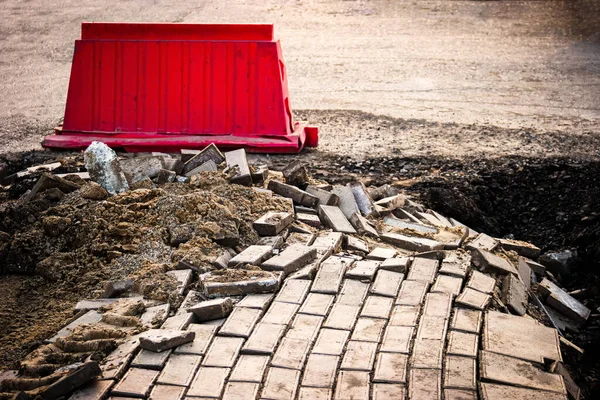 土砂崩れによる道路被害 赤いブロックで囲まれたコンクリートタイルの損傷舗装 — ストック写真