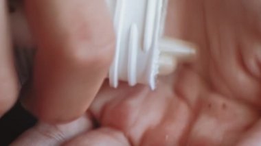 Çocuk şişeden çıkıyor. Avucunda bitkisel haplar var. Çok yakından çekilmiş.