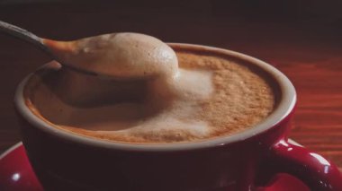 Süt köpüğü kaşıktan kahve bardağına geri düşüyor. Kahveyle oyna..