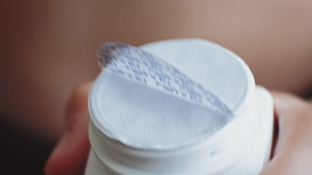 Человек, открывающий бутылку с таблетками, вытаскивает печать — стоковое видео