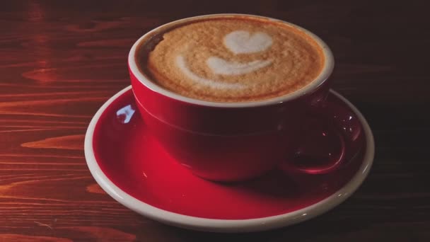 Dolly em macro shot de xícara vermelha de café na mesa de madeira — Vídeo de Stock