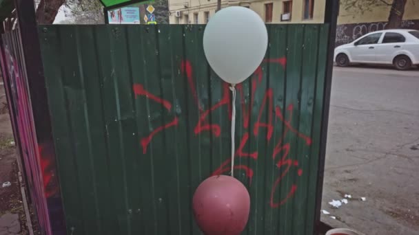 Depressie, het feest is voorbij. Rood-witte ballonnen geplaatst in de buurt van vuilnisbakken van een getto — Stockvideo