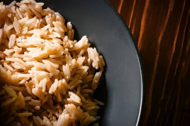 Siyah ahşap bir masanın üzerindeki pirinç kasesinin üstünde tasarımcılar için yer var..