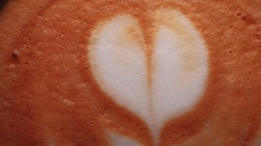 Heart shape froth art on milk coffee foam macro