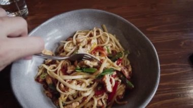 The man spinning the fork trying to get noodles on it anf move it to the camera, one of the modern popular transitions in an internet