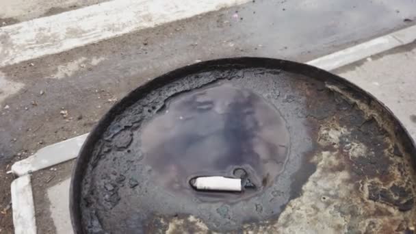 Cigarette butt lies in the urn ashtray in the street in water — стоковое видео