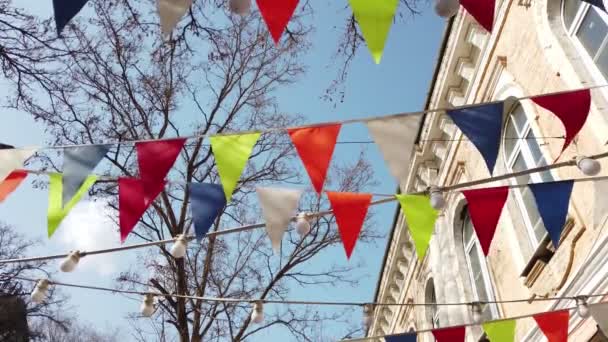 Bendera bendera segitiga warna terang di depan langit untuk dekorasi pesta, kota bersiap untuk acara perayaan kota — Stok Video