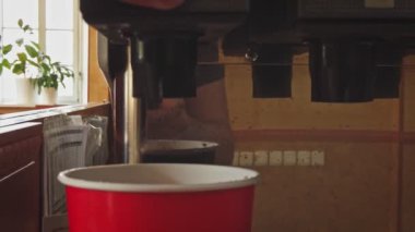 Fast food, adam meşrubatları kağıt bardağa doldurur.