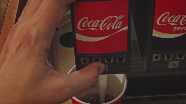 Astrakhan, Rússia, 26 de junho de 2021: Derramando refrigerante em xícara de papel com logotipo vermelho-branco Coca-Cola e metrô na máquina de venda automática dolly-in shot — Vídeo de Stock