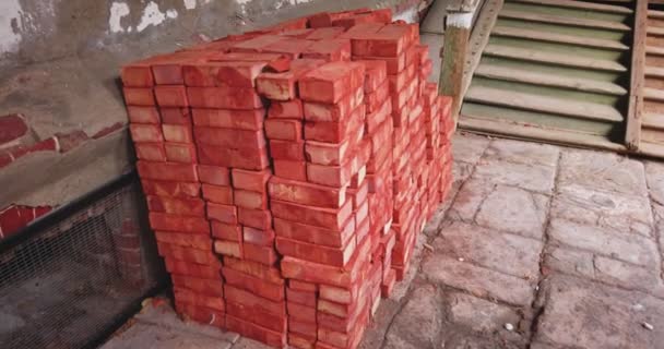 Montones de ladrillos rojos para fines de construcción en el patio de la casa vieja — Vídeos de Stock