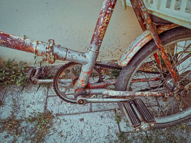 Eski Sovyet döneminden kalma eski bir bisiklet modern bir duvara yaslanmış, dişlilere ve eğri mekanizmaya odaklanmış.