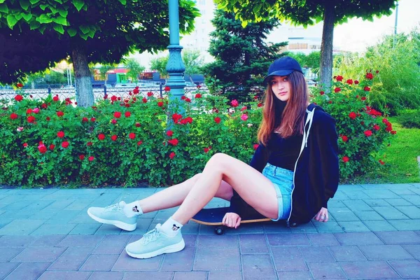 Young Beautiful Lady Sitting Skateboard Red Flowers Decorative Bush — Stock Photo, Image