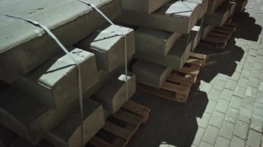 Kaldırım taşları yerleştirilmeye hazır. Sokak tamiri sırasında paletlerin üzerindeki beton kaldırımlar sokak yüzeyinde duruyor. Yol çalışmaları, kaldırım onarımı..