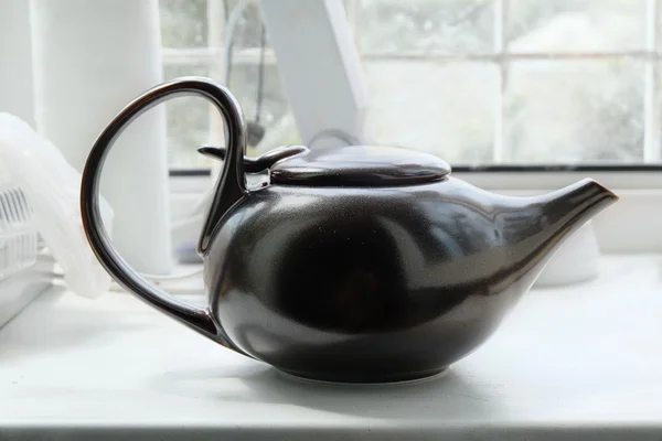 Brown asian teapot on the white windowsill — Stock Photo, Image