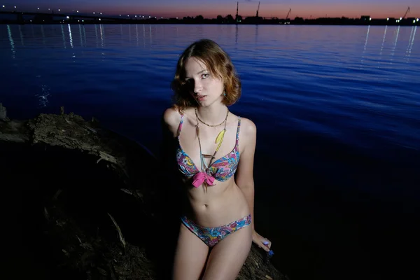 Bikini model sitting on log. — Stock Photo, Image