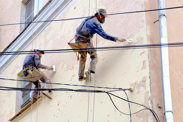 Zwei unkenntliche Maler reparieren Fassade — Stockfoto