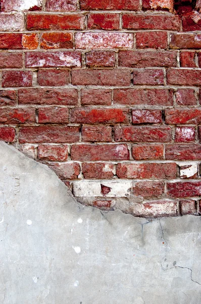 Weathered red brick wall half covered with cement — Stock Photo, Image