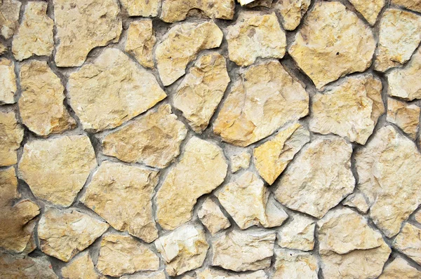 Gele wilde stenen muur achtergrond — Stockfoto