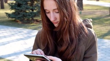 Kızıl saçlı genç kız kullanarak tablet Pc açık havada tam Hd ayak