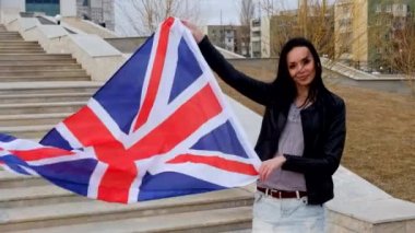 Union Jack bayrak sallayarak tutan İngiliz Latin kadın