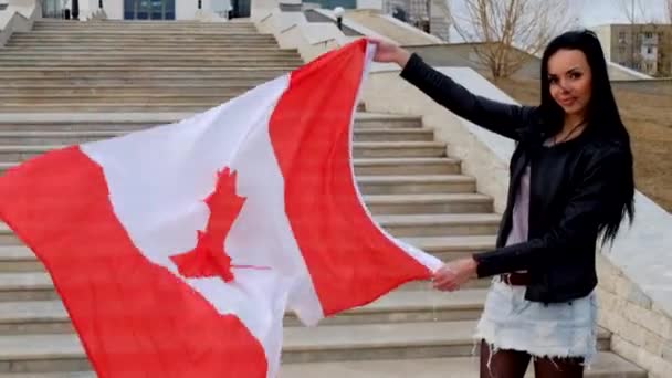 Portret van een brunette meisje met Canadese vlag buiten — Stockvideo