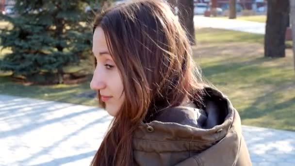 Belle adolescente rousse regardant en arrière et souriant à l'extérieur — Video