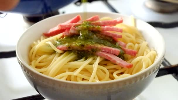 Putting green pesto sauce on spaghetti — Stock Video