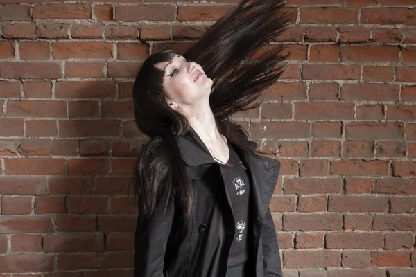 Happy hipster gil shake her hairs against red brick wall with copyspace — Stock Photo, Image