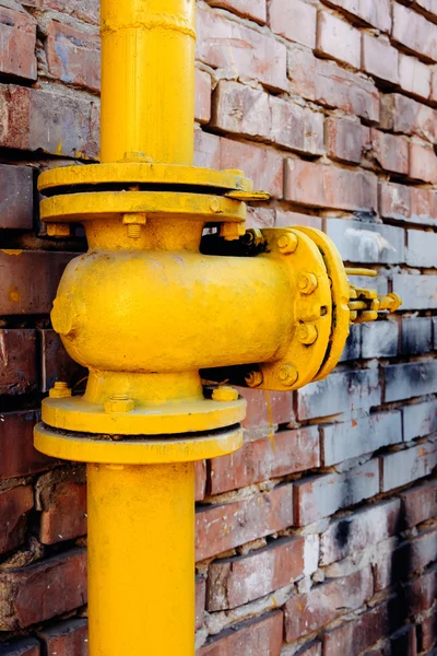 Válvula de gas amarillo sobre pared de ladrillo rojo —  Fotos de Stock