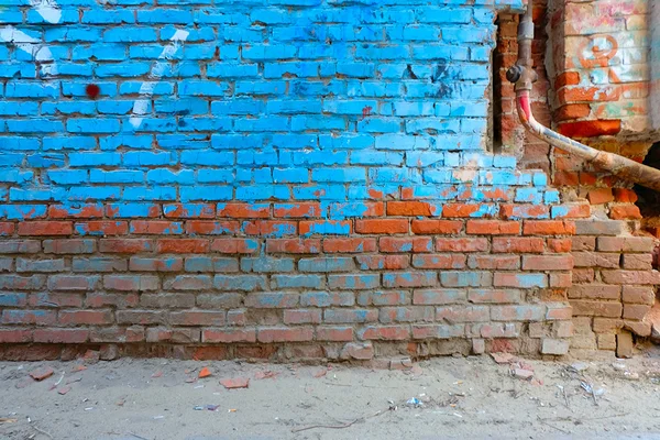 Eski tuğla yarı parlak mavi renk ve paslı su borusunun boşaltmak çok boyalı duvar — Stok fotoğraf