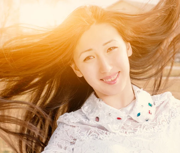 Krása romantická dívka venku Closeup. Krásná asijská dospívající Model dívka v neformální oblečení s Jevels ve světle slunce. Foukání dlouhé vlasy. Na podzim. Záře slunce, sluníčko. Podsvícení. Posílený v teplých barvách — Stock fotografie