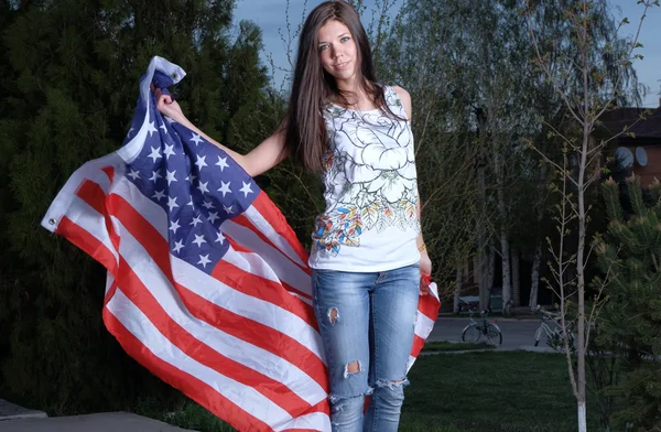Mulher bonita com bandeira americana ao ar livre — Fotografia de Stock